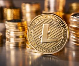 standing golden Litecoin coin with a stack of coins in the background