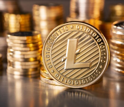 standing golden Litecoin coin with a stack of coins in the background